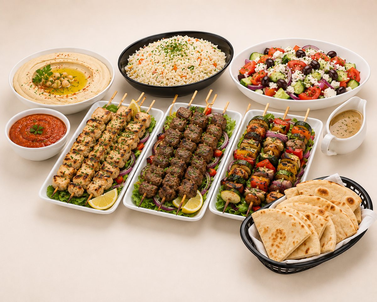 Greek kebab buffet with chicken and beef skewers, Greek salad, hummus and pita