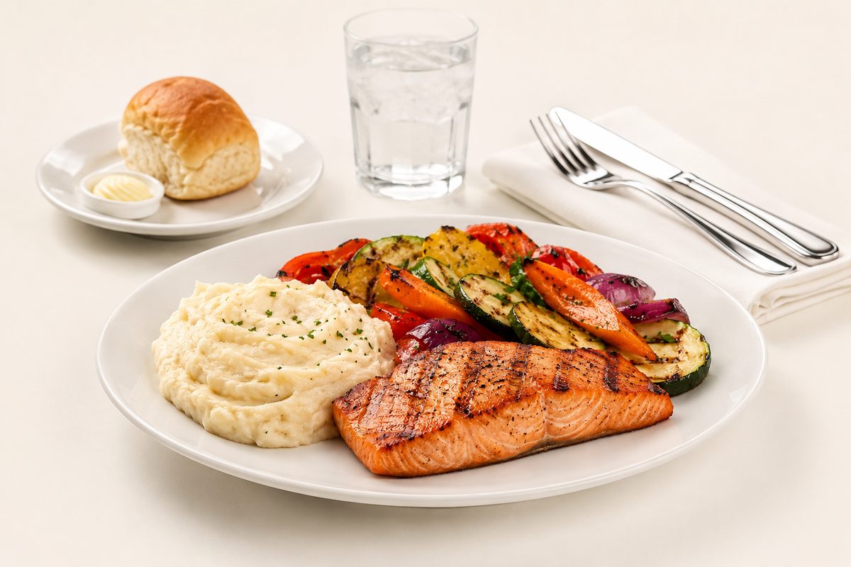 Grilled salmon with mashed potatoes and roasted vegetables from a hot entree buffet